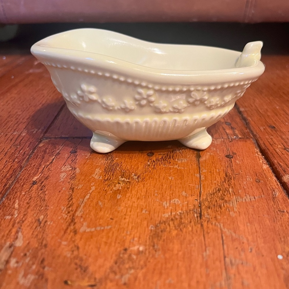 Vintage butter yellow ceramic soap dish shaped like bathtub.
